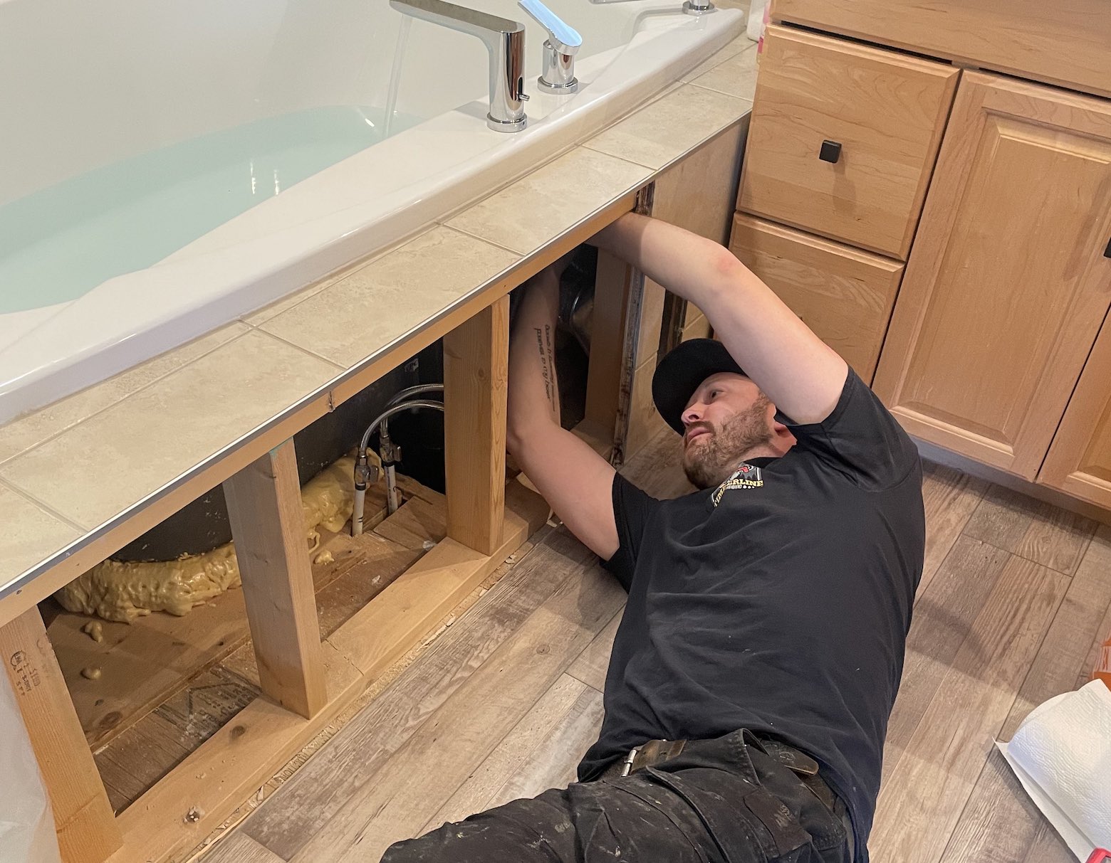 Troy fixing the plumbing of an ensuite bathtub